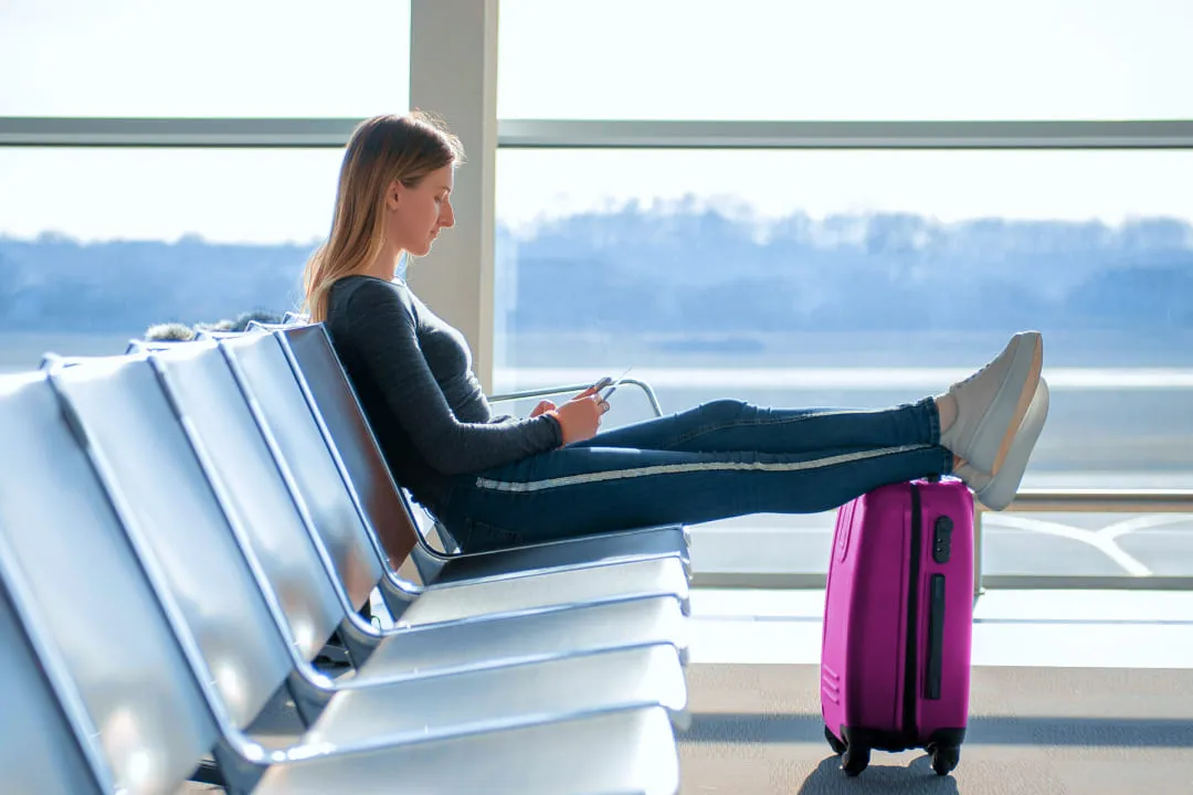Girl put her feet on a purple suitcase