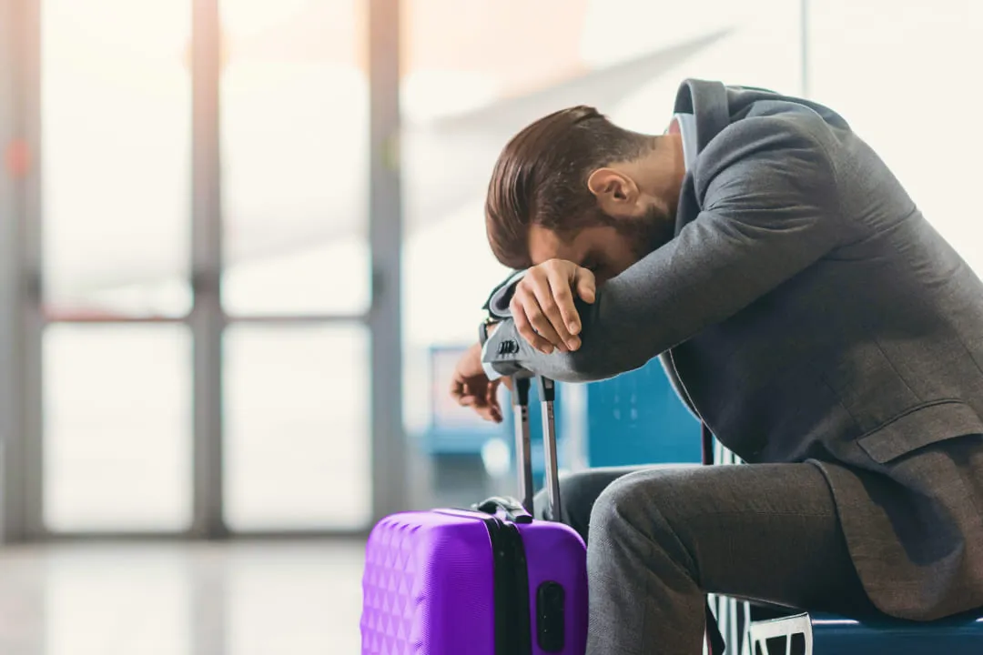 Man resting his head on a suitcase
