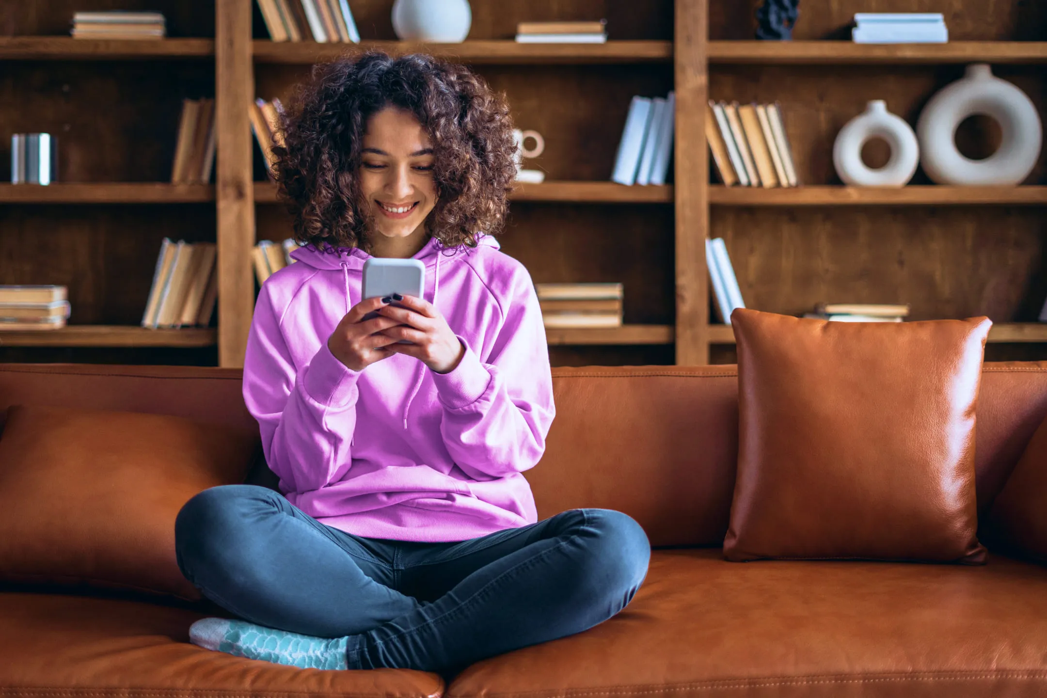 A girl smiling and looking at her phone