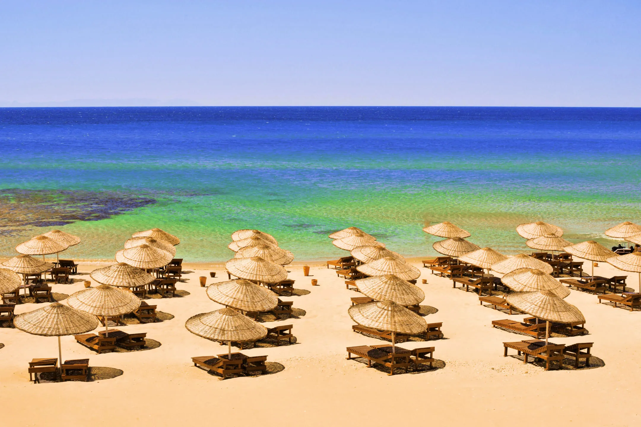 Sun loungers with beach umbrellas near the sea