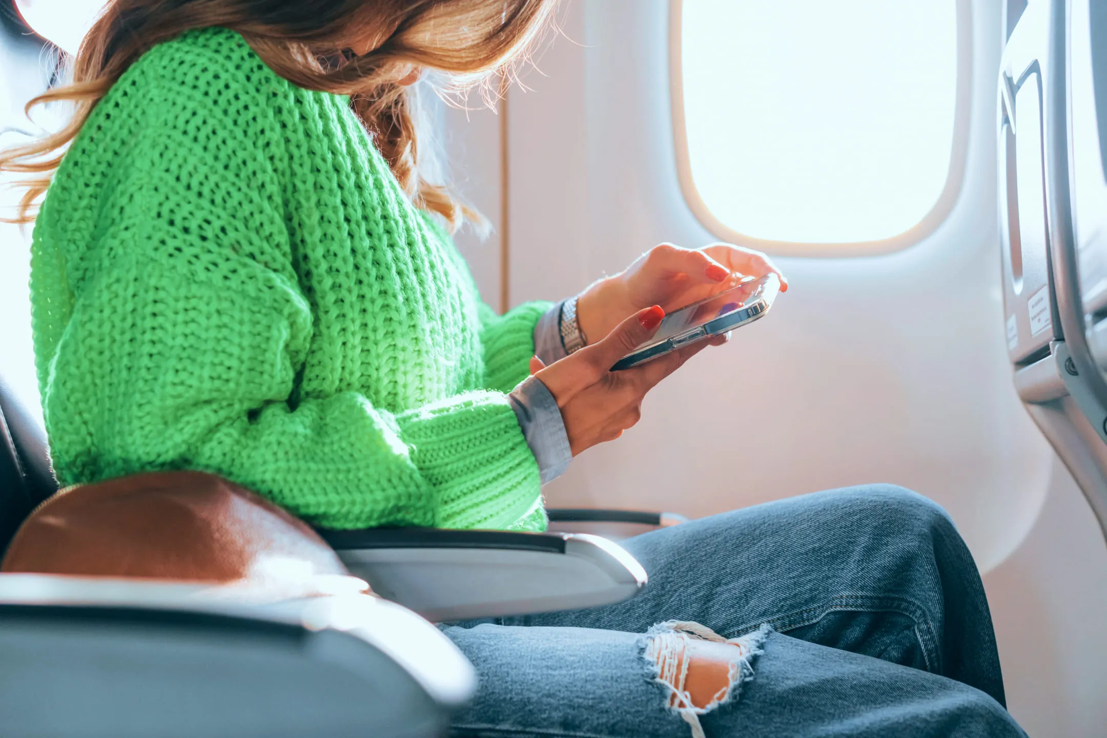 Girl with a phone on a plane