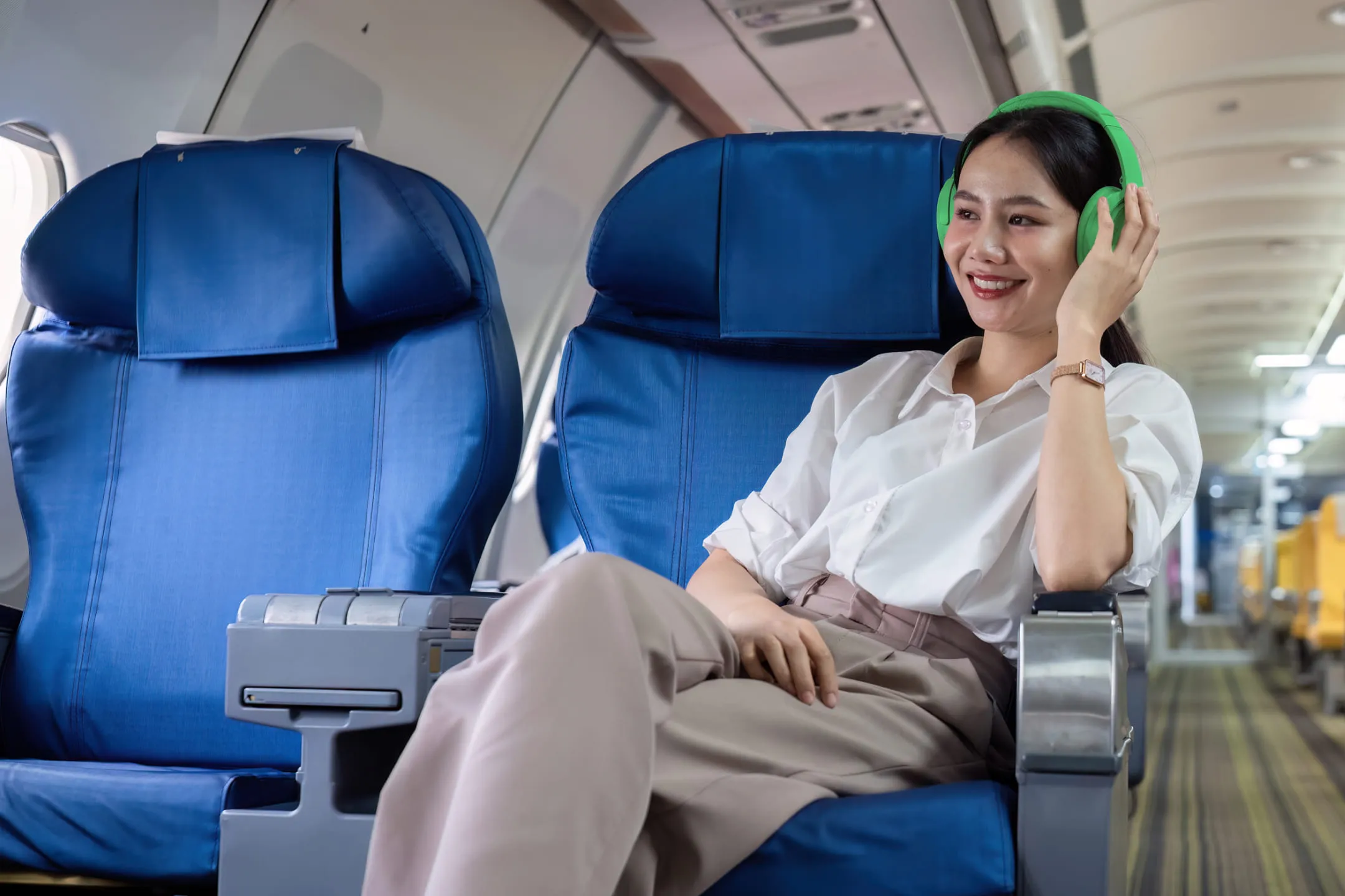 Girl with green headphones on a plane