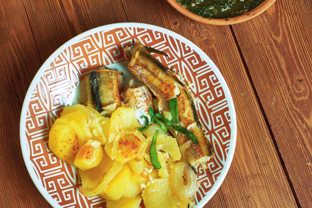 Fried fish on a decorated plate with potatoes