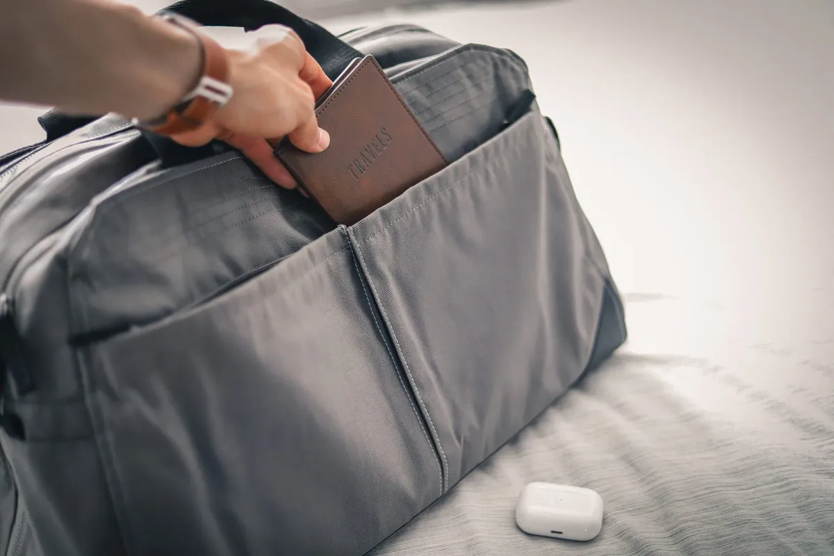 Person putting passport into a bag