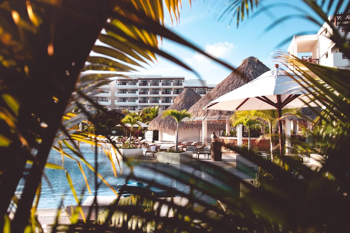 View of the hotel among palm leaves
