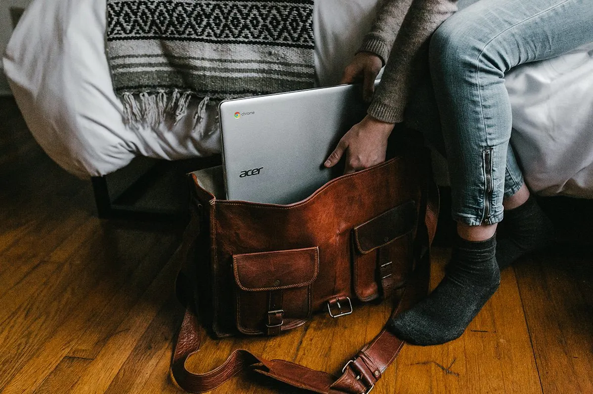 Girl putting laptop into bag