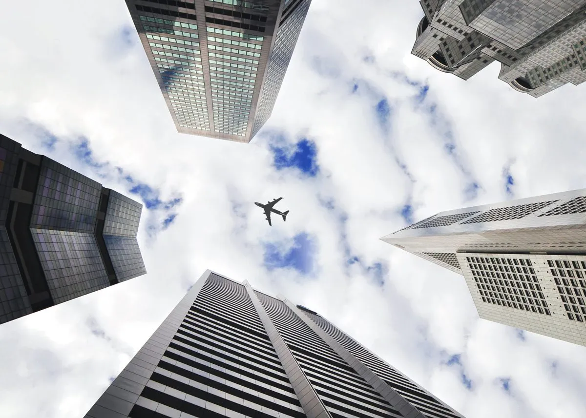 Airplane flying over skyscraper roofs