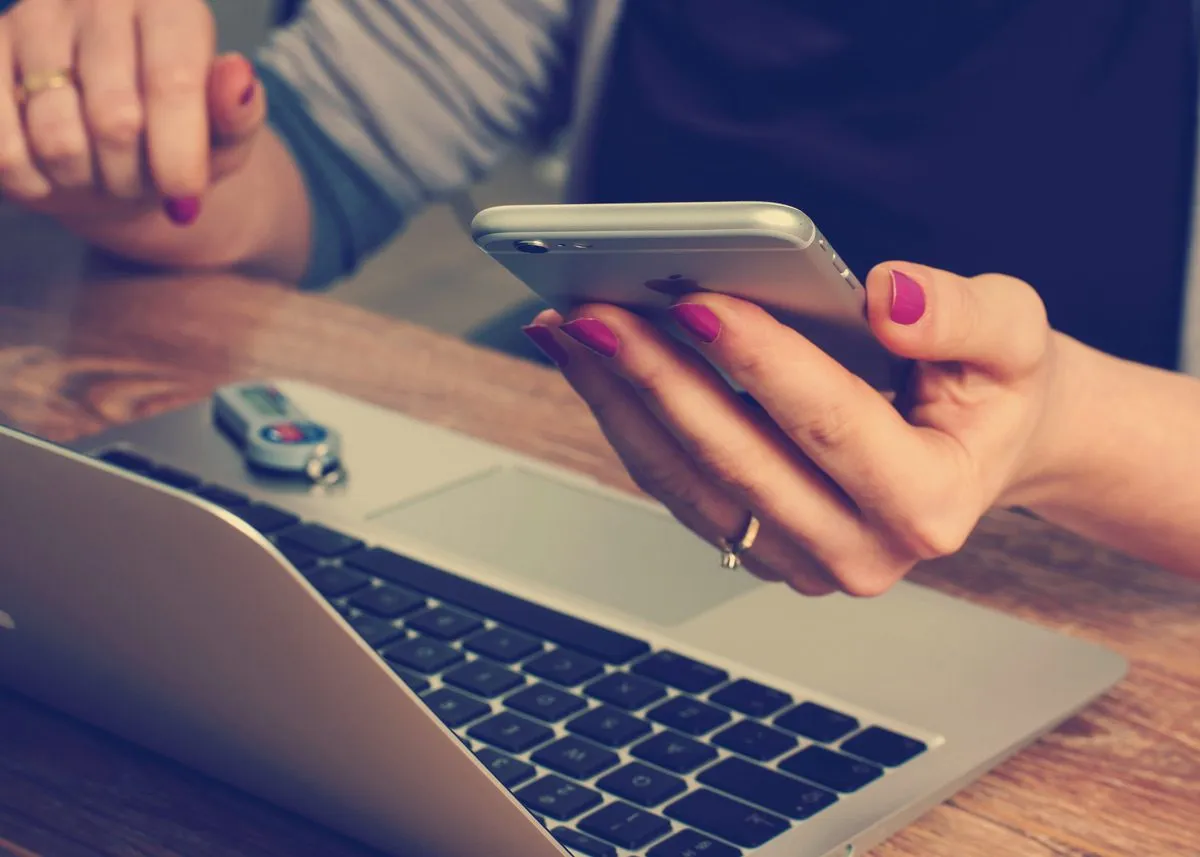 Girl checking information on phone and laptop