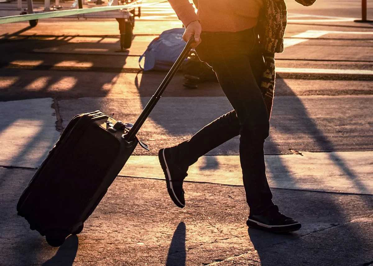 Person rushing to a plane with hand luggage