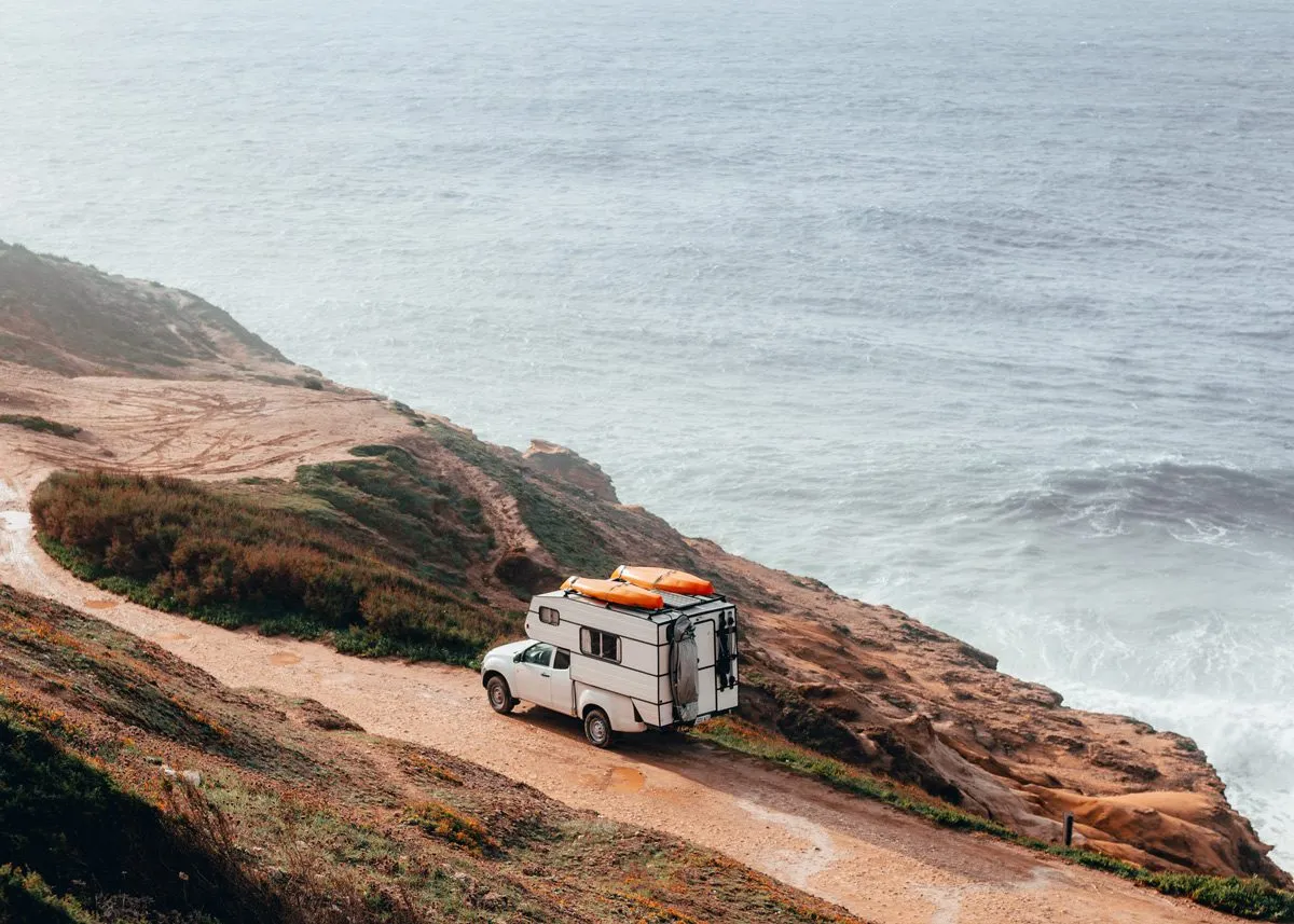 Car driving past a cliff