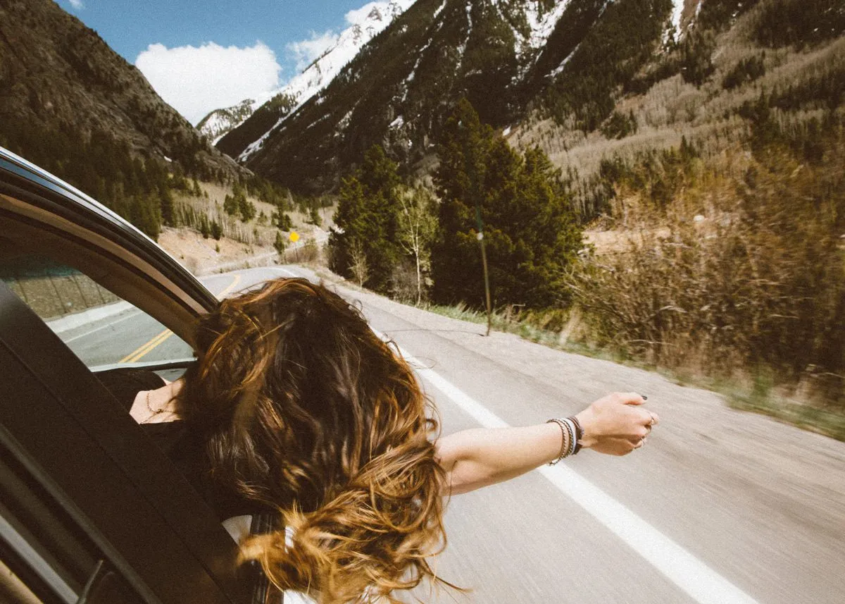 Girl sticking her head out of a car window