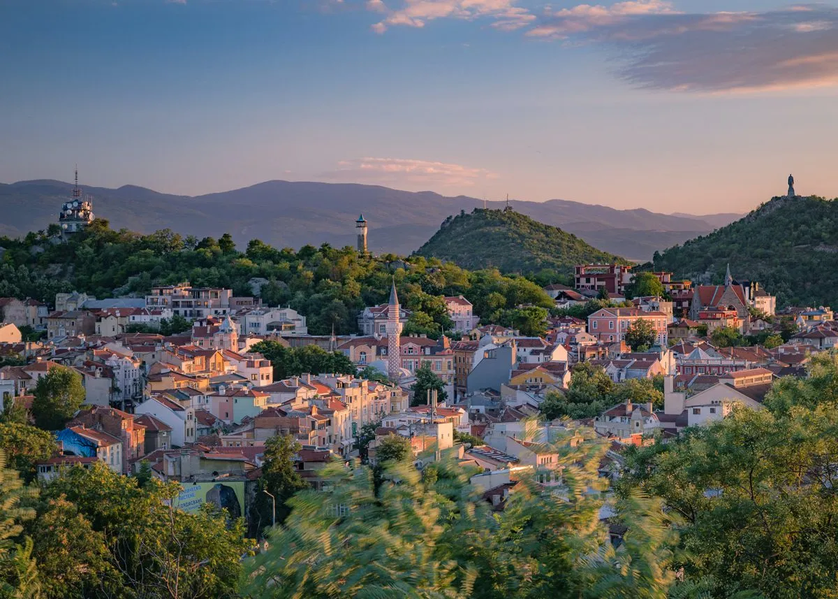 City among mountains in the rays of the rising sun
