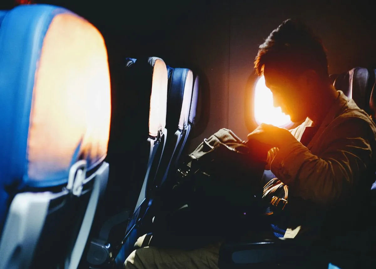 Man checking his belongings on a plane