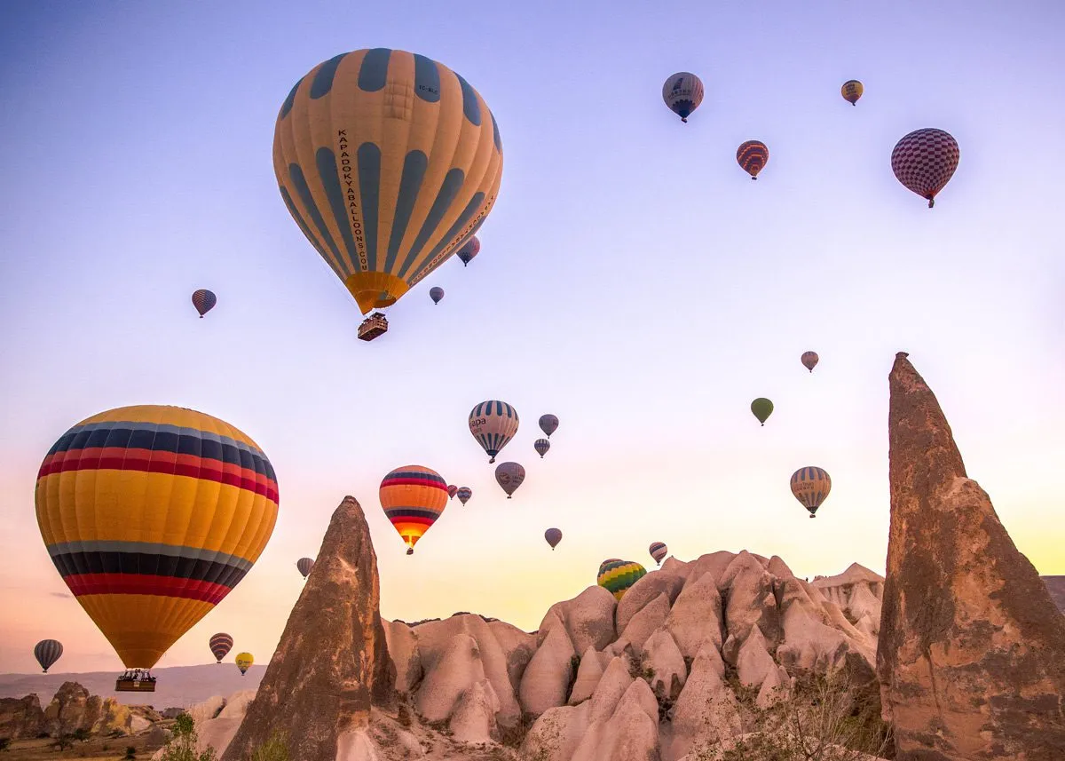 Bright hot air balloons rise above the mountains