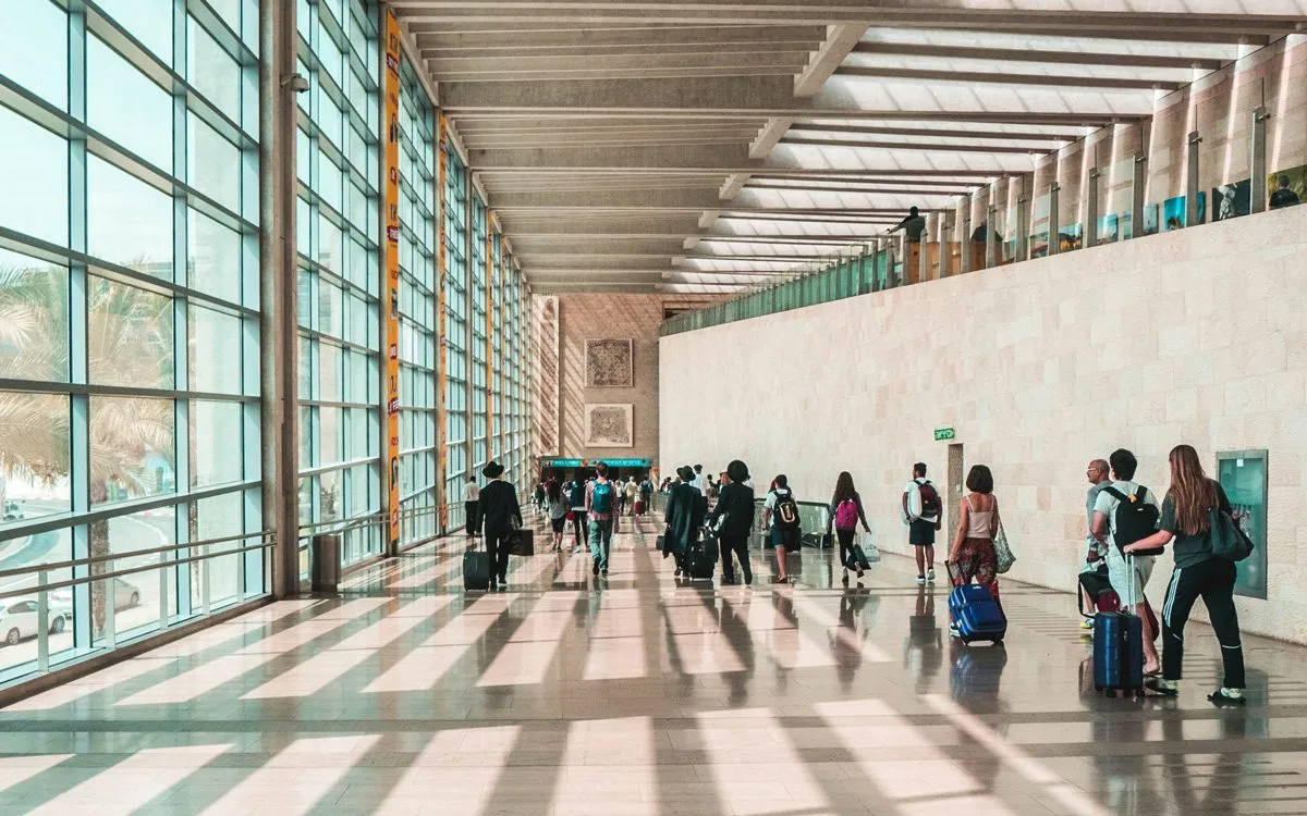 People with suitcases heading towards the airport exit