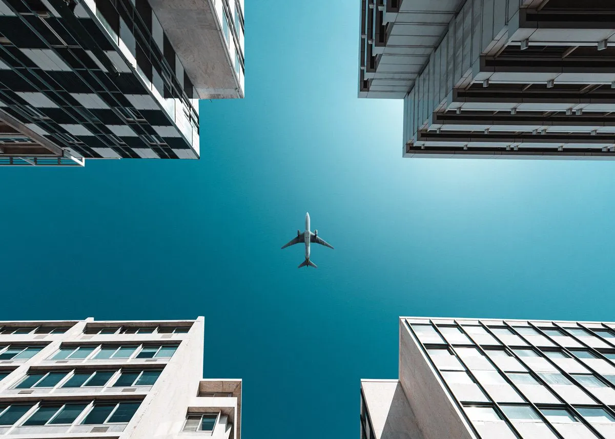 A plane flying over skyscrapers