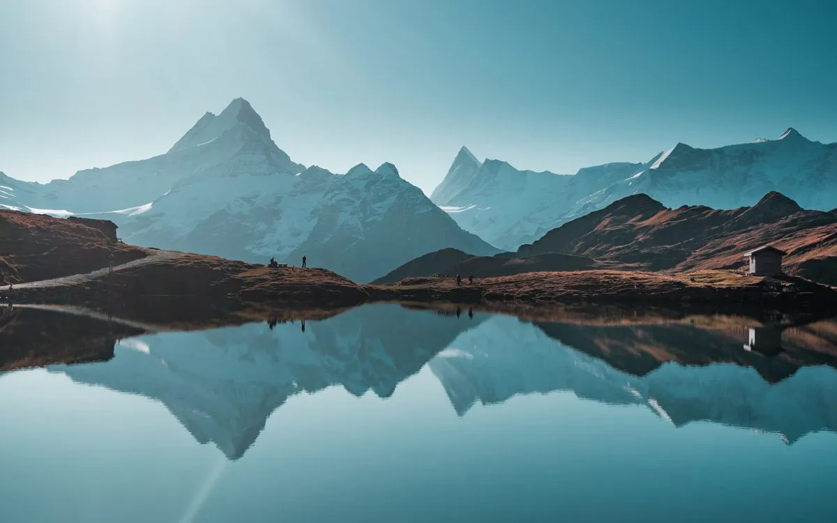 Mountains and a small house reflected in a lake