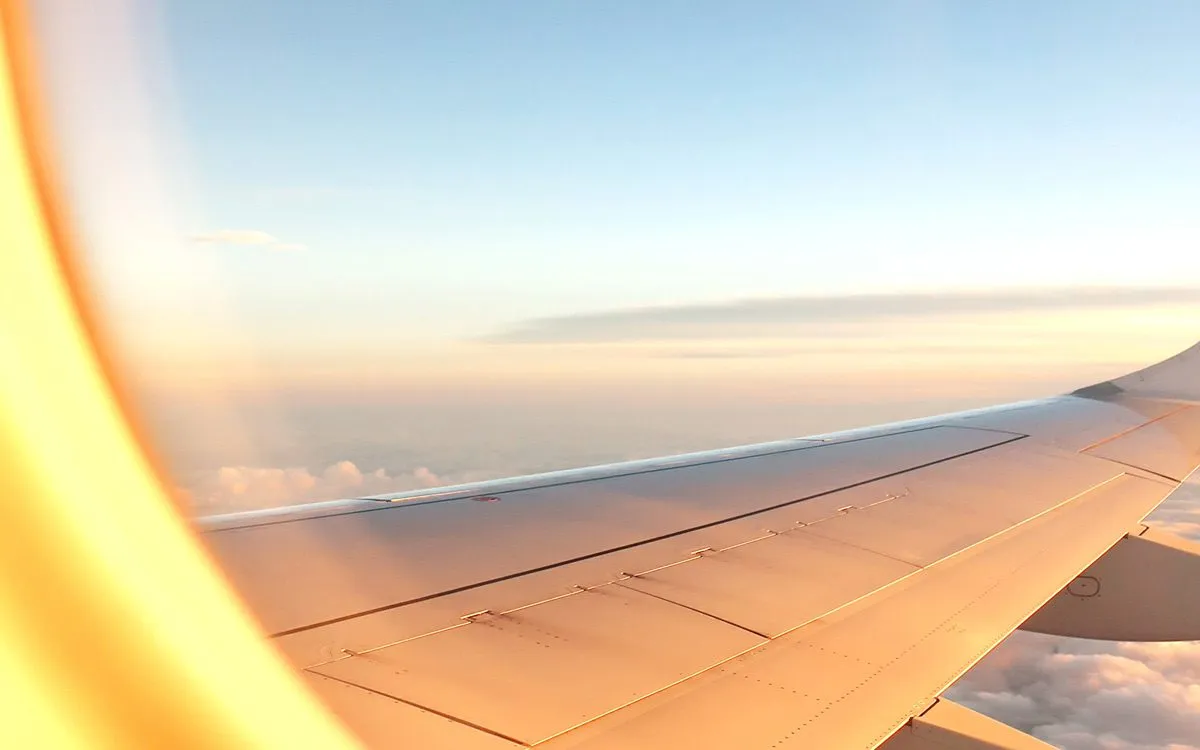 Airplane wing in the sun's rays at dawn