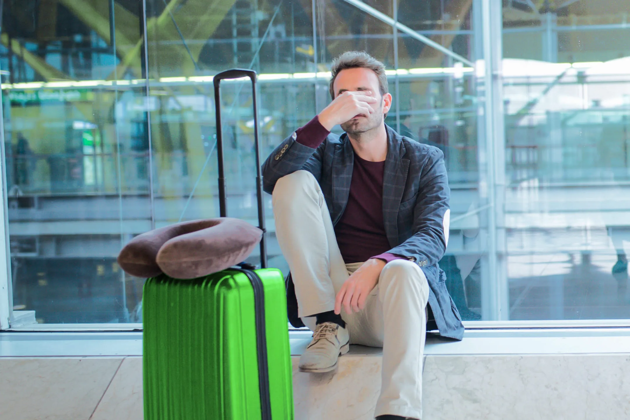 Man with a green suitcase at the airport