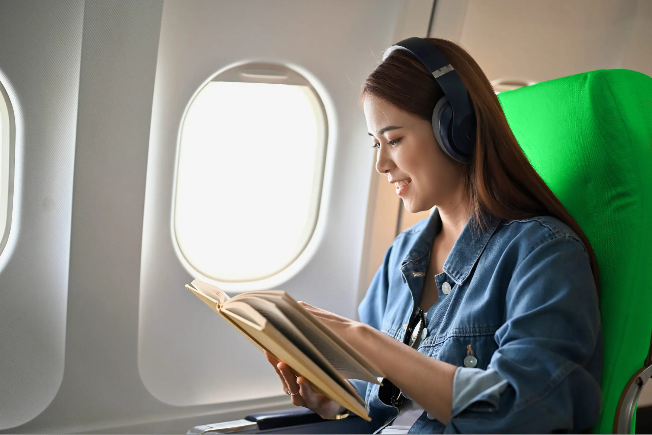 Girl reading a book on a plane