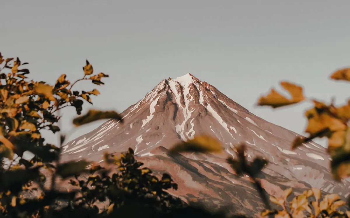 The visible peak of a volcano among trees